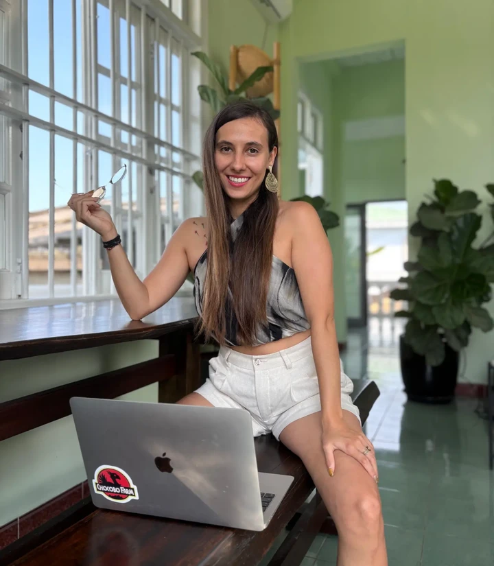 Manon Cressent, souriante devant son ordinateur dans un décor végétalisé
